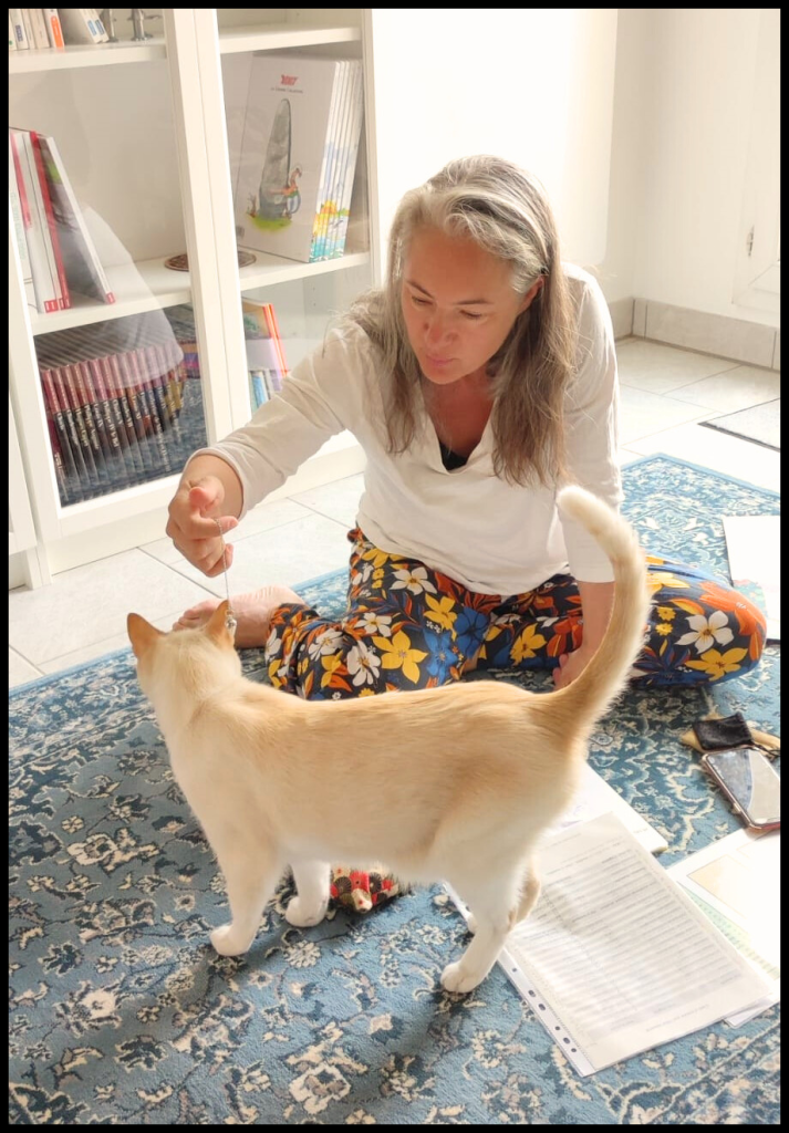 Photo de la praticienne en soin énergétique grâce au pendule avec un chat roux clair qui s'appelle Yuki